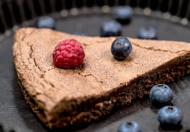 chocolate tart with raspberry and blueberries in a nostalgic baking dish - Fotó, kép