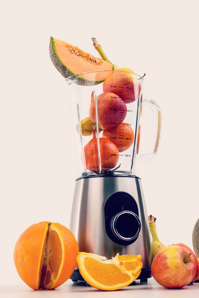 blender with a lot of fruits in front of white background - 写真・画像