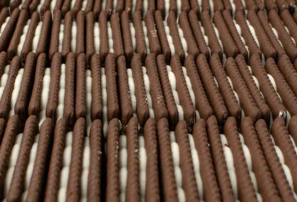 白いクリーム色の充填パターンの柔らかいチョコレートバタークッキー - 写真・画像