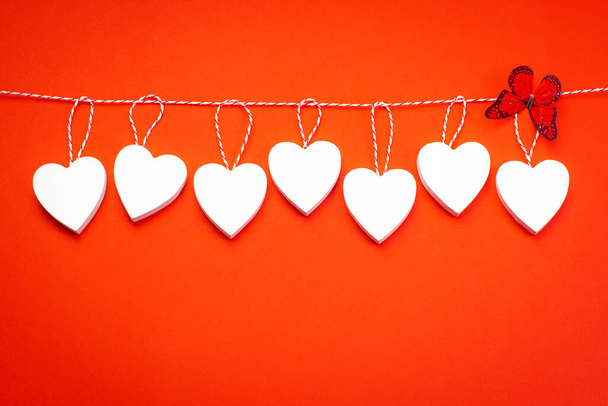 День святого Валентина концепция. Поздравительная открытка. Принято. День Святого Валентина. Белые деревянные сердца на красном фоне. Пропуск для дизайнера
. - Фото, изображение