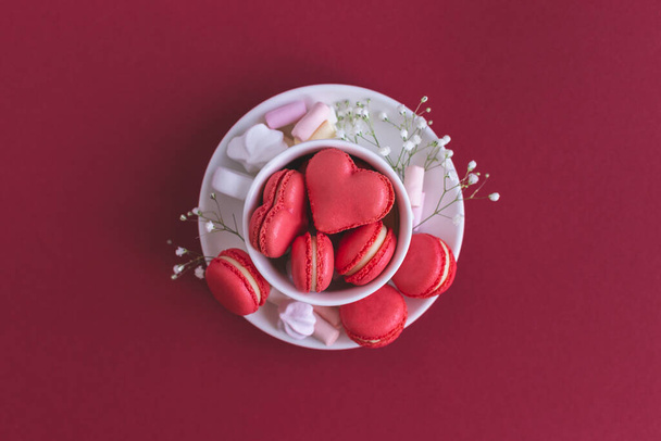Valentin-napi háttér rózsaszín szív alakú makarónival és mályvacukorral. - Fotó, kép
