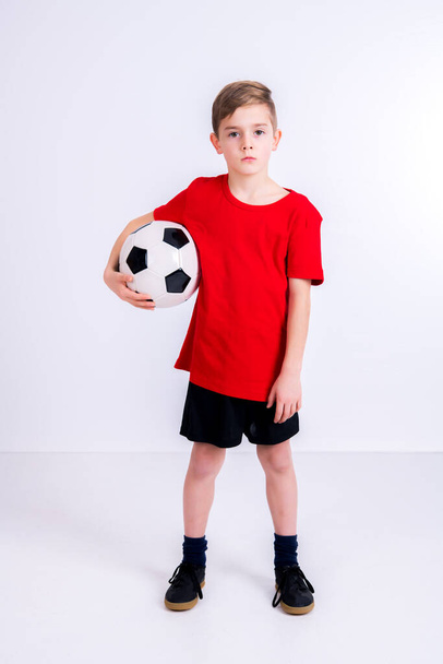 boy in red shirt with soccer ball in front of white background - Fotó, kép