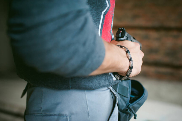 man pulls a gun out of his bag, holding it in his hand - Photo, Image