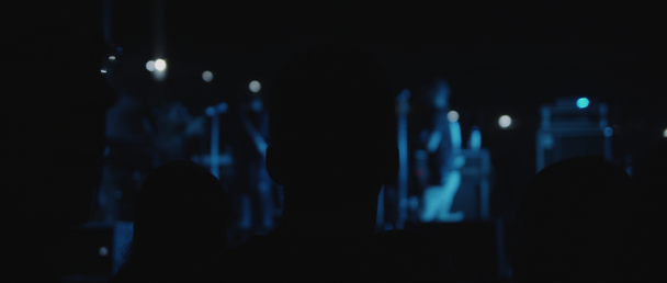 Takana kuva ihmisistä siluetteja aikana live show konsertti bändi, yökerhossa. sininen valaistus. Lähemmäs, taakse ammuttu, käsikäyttöinen, hidastettu. BMPCC 4K
  - Materiaali, video