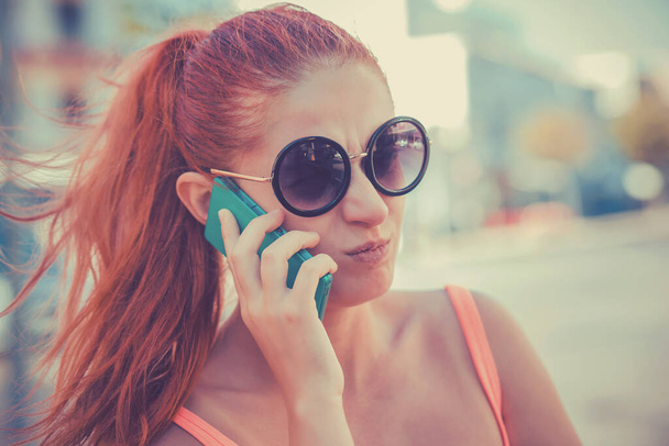 Angry woman phone talking. Closeup young unhappy frustrated disapointed beautiful woman girl lady talking on mobile cellphone on cityscape outdoor background.  - Zdjęcie, obraz
