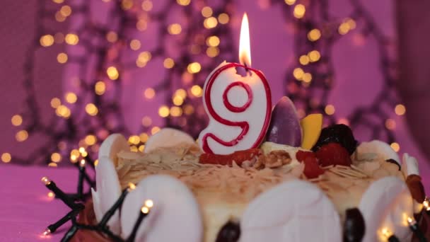 Hořící svíčka v dort slavnostní narozeniny pozadírůžové - Záběry, video