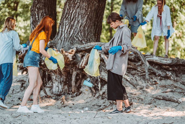 Група активістів друзів, які збирають пластикові відходи на пляжі. Охорона навколишнього середовища
. - Фото, зображення