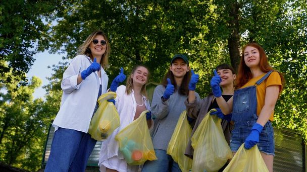 Группа друзей активистов собирает пластиковые отходы на пляже. Охрана окружающей среды
. - Фото, изображение