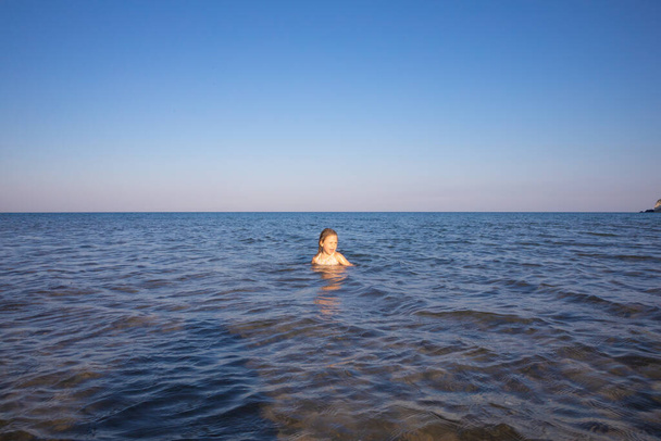 голова маленькой девочки торчит из воды Средиземного моря
  - Фото, изображение