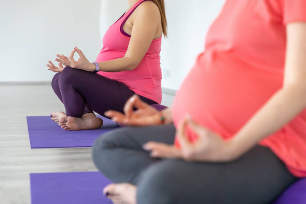 Las mujeres embarazadas están haciendo yoga y madición en la clase de yoga, estilo de vida prenatal saludable
 - Foto, Imagen