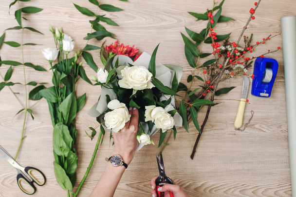 Gardener's in the flower shop make bouquet. Lifestyle flower sho - Photo, Image