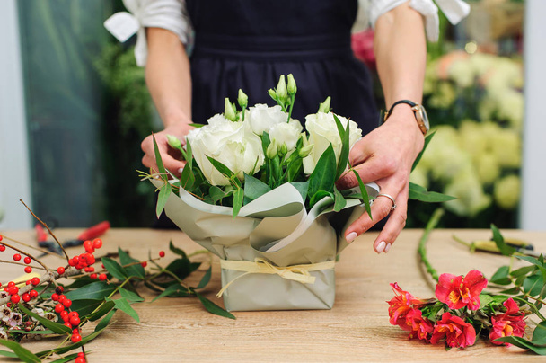 Gardener's in the flower shop make bouquet. Lifestyle flower sho - Photo, image
