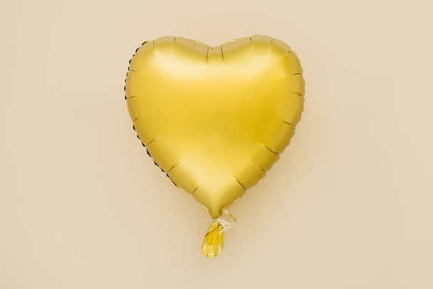 Single gold Foil Balloon of heart shaped. Love concept. Holiday celebration. Valentine's Day or birthday/bachelorette party decoration. Metallic balloon  - Fotoğraf, Görsel