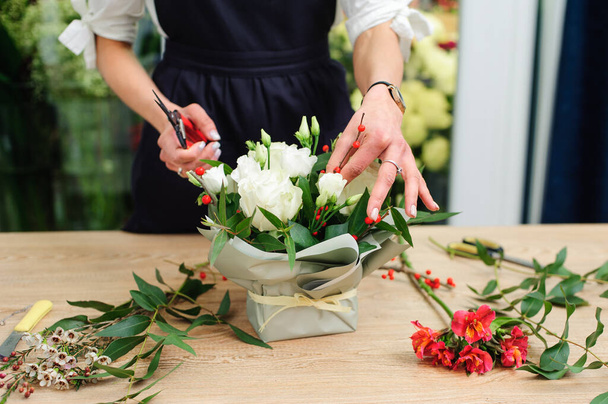 Gardener's in the flower shop make bouquet. Lifestyle flower sho - Foto, afbeelding