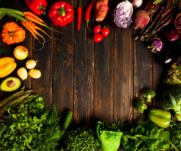 Vegetables, greens and herbs on dark wood - Фото, изображение