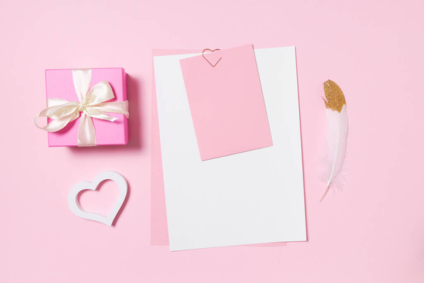 Empty template for romantic letters on a pink background. White feather with gold plating. Real photo, flat lay. Copy space for text. - Photo, image