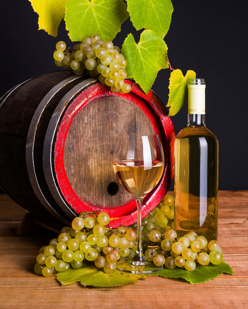 White wine and grapes in front of old barrel - Foto, afbeelding