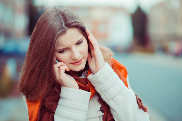 I do not hear you. Closeup portrait beautiful woman girl talking to the phone listening carefully trying to hear understand the conversation isolated city scape blurred background of Brussels Belgium  - Фото, зображення