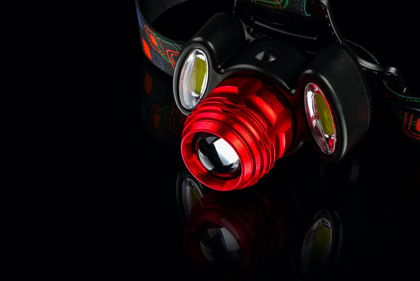 anodized aluminium waterproof tactical flashlight headlamp on black background - Fotó, kép