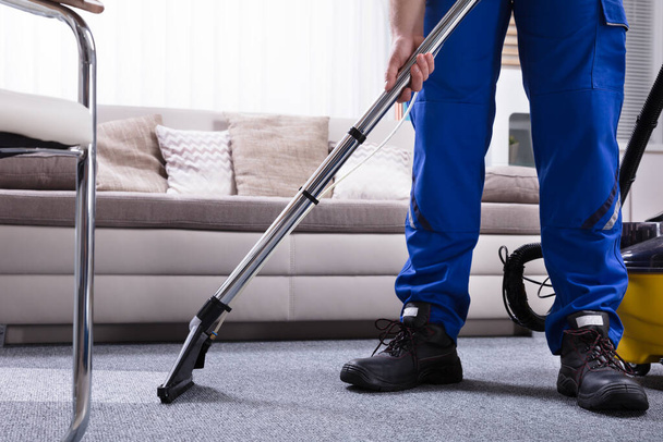 Janitor's Hand Cleaning Carpet With Vacuum Cleaner - Photo, image