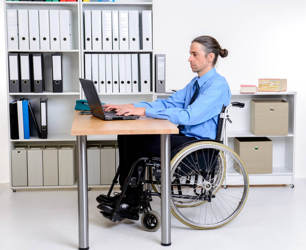 disabled business man in wheelchair working with the computer - Fotó, kép