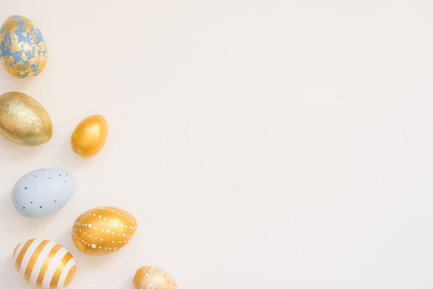 Frame of Easter golden decorated eggs in solated on white background. Minimal easter concept. Happy Easter card with copy space for text. Top view, flatlay - Foto, Imagen