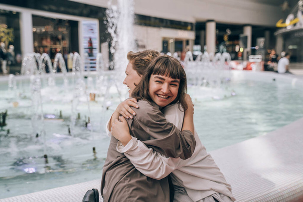 Due ragazze si divertono al centro commerciale, una fontana sullo sfondo
 - Foto, immagini