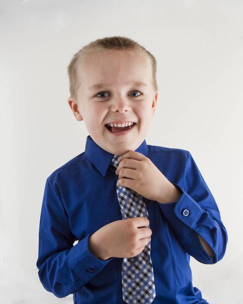 Boy adjusting his tie before his first pretend day of work. - Foto, Imagem