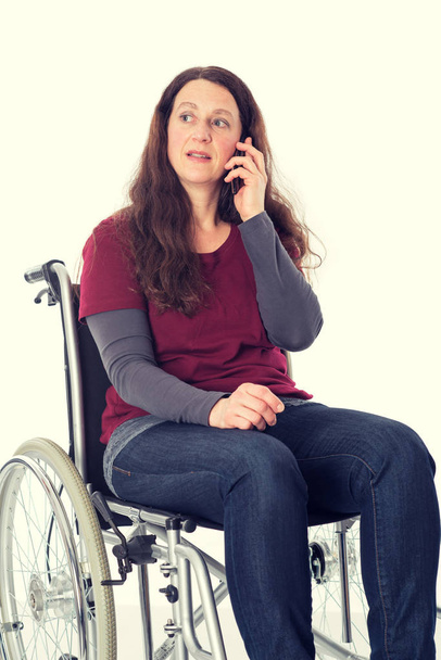 молодая женщина в инвалидной коляске звонит с мобильного телефона
 - Фото, изображение