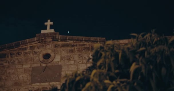 Üzerinde haç olan antik Katolik kilisesi ve arka planda karanlık gece gökyüzü, el bilgisayarı, yavaş çekim. Bmpcc 4k - Video, Çekim