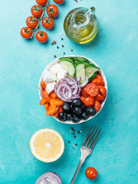 Greek Salad Bowl on blue background, copy space. Above view of Bowl Greek Salad. Trendy food. Idea, recept and concept of modern healthy food. Vertical. - 写真・画像