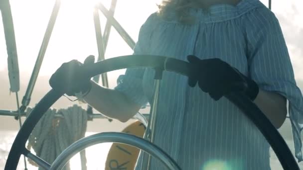 Kapitän eines Segelbootes auf ihrer Jacht. Ladys Hände in Handschuhen halten ein Bootsrad - Filmmaterial, Video
