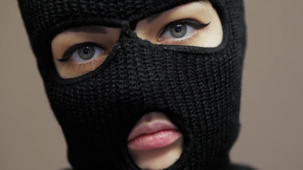 Close-up portrait of sexy woman dressed hacker black balaclava mask with beautiful eyes - Footage, Video