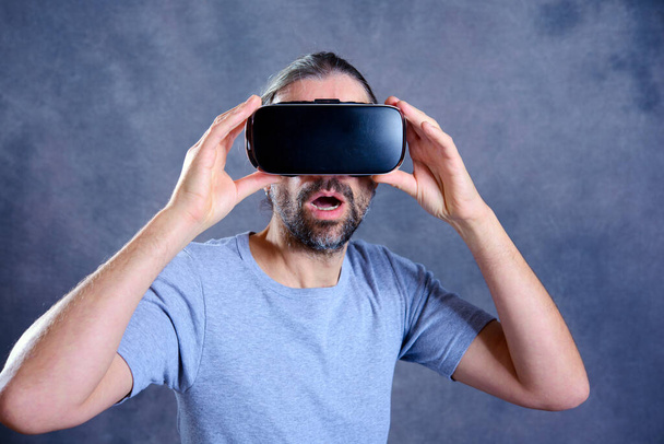 young man with virtual reality glasses looking surprised - Photo, Image