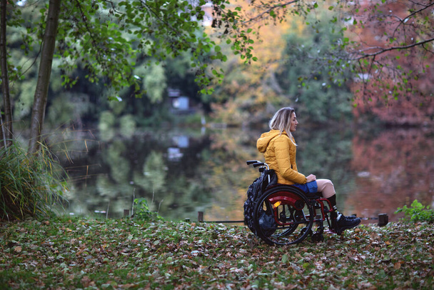 Una donna disabile senza gambe si siede su una sedia a rotelle
. - Foto, immagini
