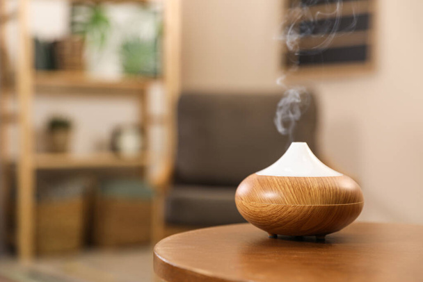 Aroma oil diffuser on wooden table at home, space for text. Air freshener - Fotografie, Obrázek