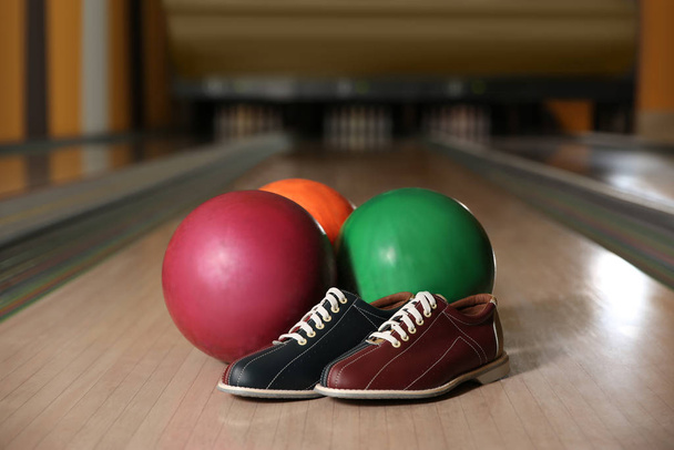 Shoes and balls on bowling lane in club - Photo, Image