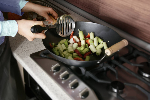 an image of a woman cooking leek - Zdjęcie, obraz