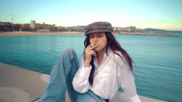 Porträt einer jungen schönen, stylischen Frau in weißem Hemd und grauer Mütze - Filmmaterial, Video