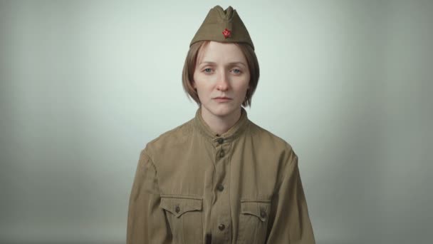 Video of young woman wearing soviet army uniform on white - Footage, Video