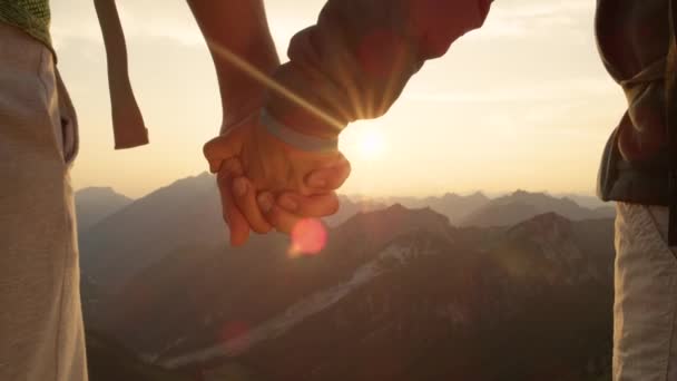 Повільний рух: Пара подорожей по Альпах тримається за руки після досягнення вершини.. - Кадри, відео