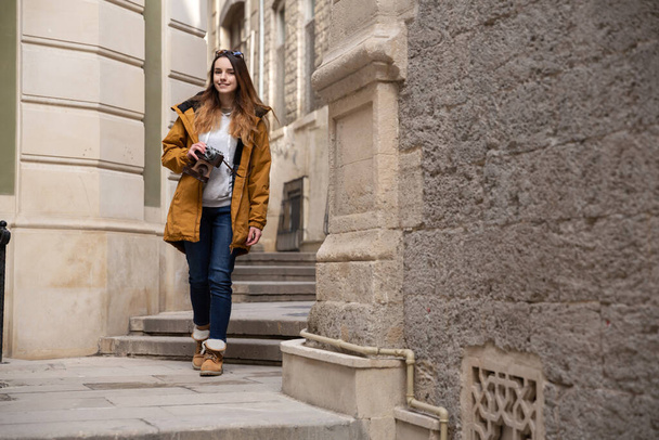 Foto eines jungen Touristenmädchens, das die Straßen von Baku erkundet. Stimmungsvolle Fotos von Teenager-Mädchen, die die Altstadt besuchen und Fotos von der Stadt machen. - Foto, Bild
