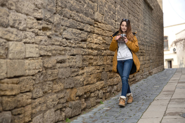 Photo of young tourist girl exploring streets of Baku. Moody photos of teenager girl visiting old city and taking photos of the city. - Foto, Imagem