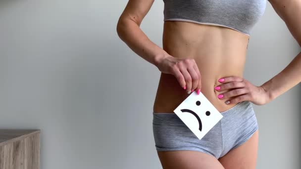 Zdraví ženy. Ženské tělo drží smutný úsměv kartu v blízkosti žaludku - Záběry, video