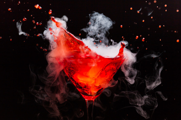 Roter Cocktail mit Spritzer und Eisdampf - Foto, Bild