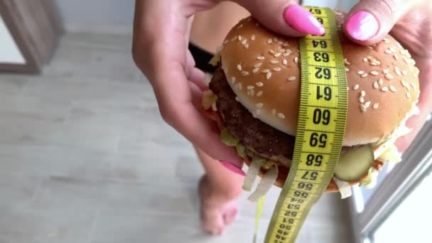 Kobieta chce zjeść hamburgera, ale utknął skochem usta - Materiał filmowy, wideo