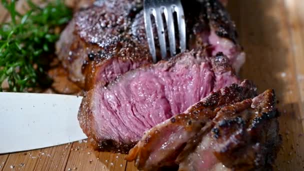 Κομμάτι του Tom-A-Hawk Steak closeup. Κατανάλωση βοείου κρέατος. - Πλάνα, βίντεο