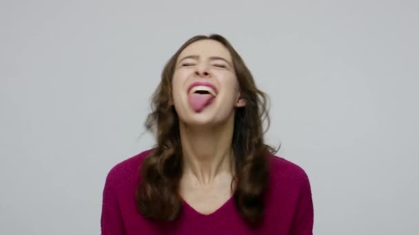 Funny playful nice-looking brunette woman in pullover sticking out tongue, having fun - Video
