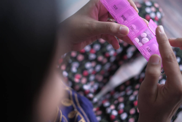 Read view of women taking medicine from pill container - Photo, Image