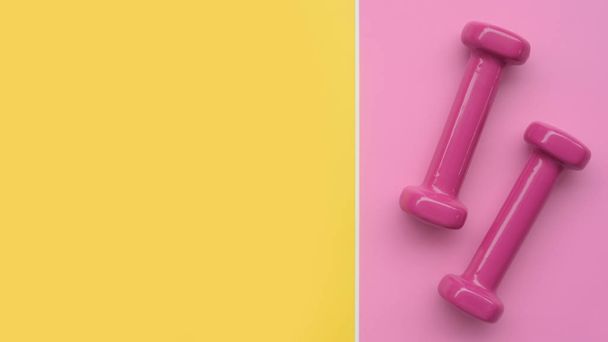 close up of dumbbell on pink and yellow background - Photo, Image